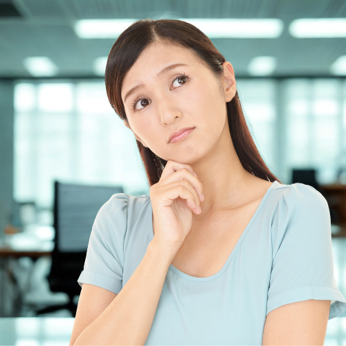 オフィス内で軽く上を向き、忘れものを思い出している20歳代の日本人女性